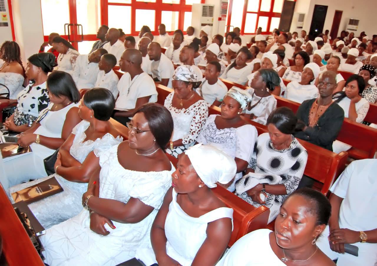 Congregation holding memorial keepsake brochure for the late Nicholas Nii Adamma Ammah